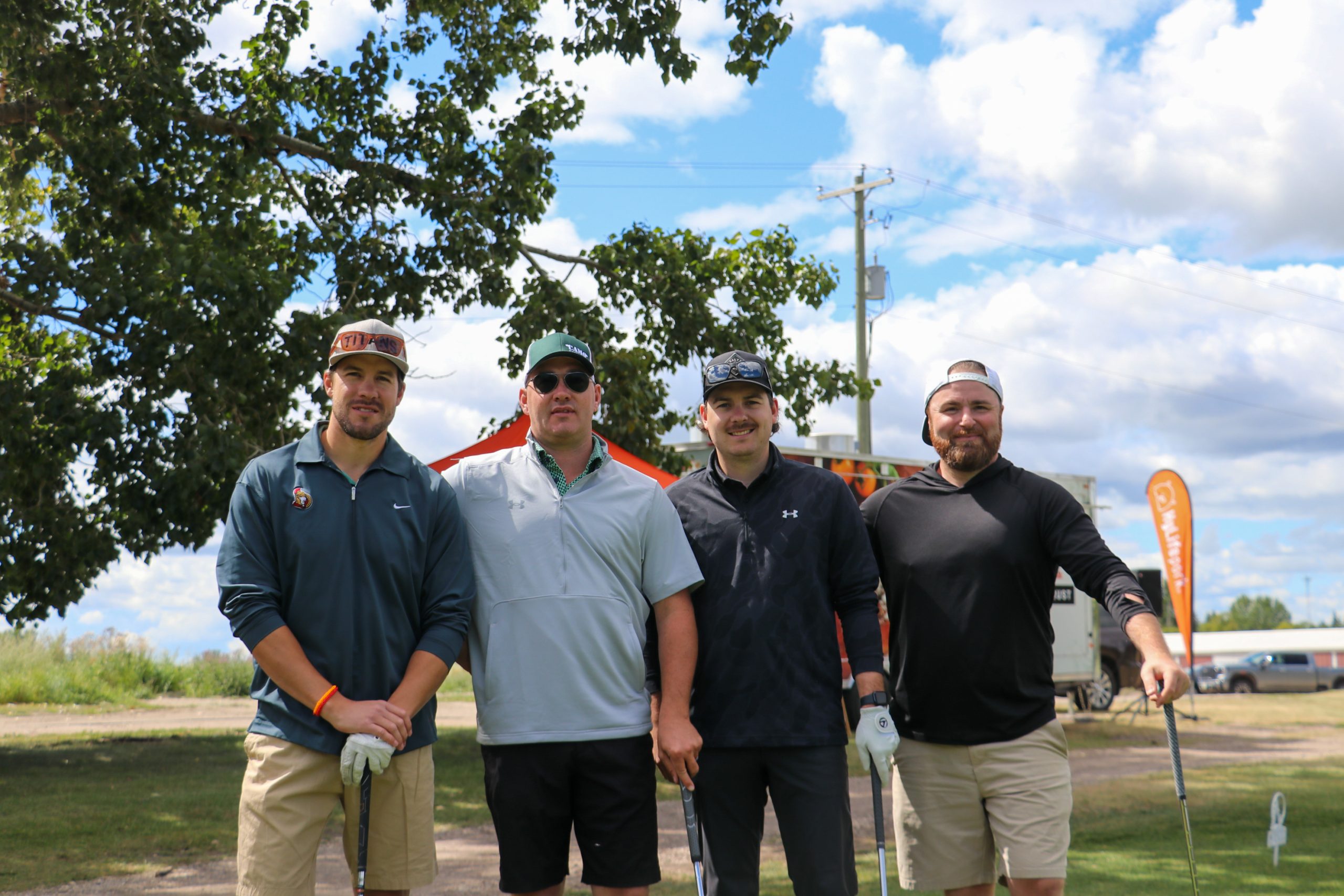 Golfers posing infront of HyLife's food truck