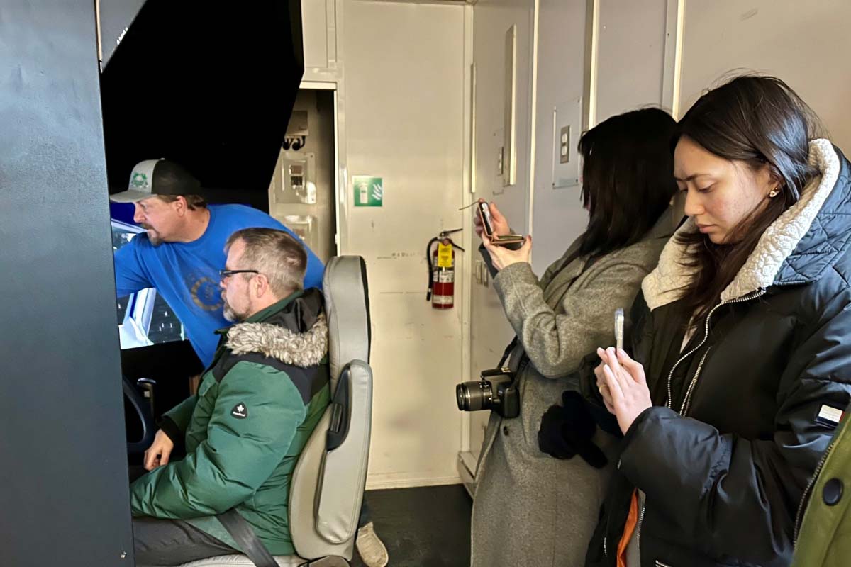 Inside view of the HyLife driver simulator showing participants preparing for challenging driving conditions